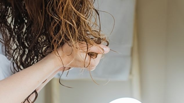Mulher aplicando máscara de hidratação para cabelo para manter os fios hidratados.