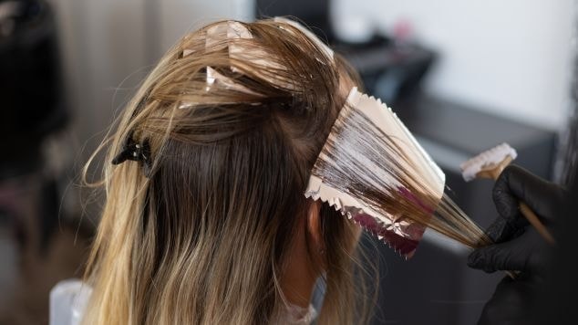 Mulher vai ao profissional cabeleireiro para realizar o tratamento para tirar o verde do cabelo.