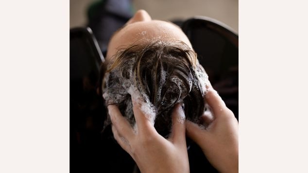 Profissional prepara o cabelo de uma cliente para aplicar a tinta de cabelo e explica se pode lavar o cabelo depois de pintar