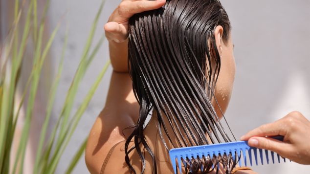 Mulher penteia o cabelo após a acidificação com vinagre para cabelos porosos