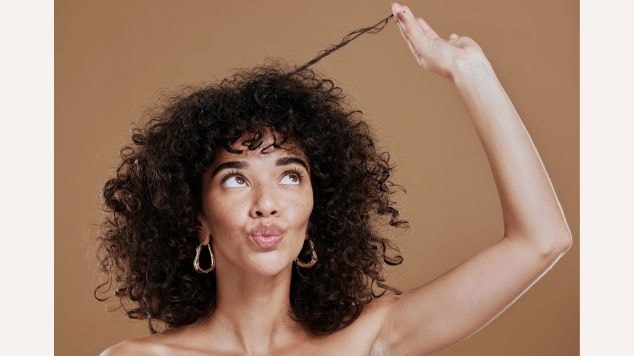 Mulher com cabelo com cachos e franja desfiada no cabelo cacheado