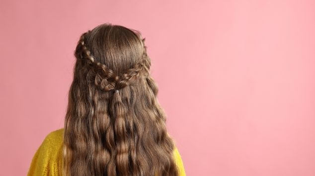 Cabelo ondulado de uma jovem com duas tranças embutidas para o Carnaval